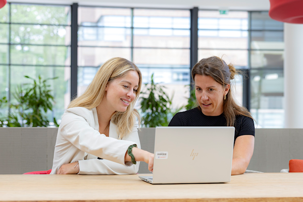 illustratie 2 dames kijken op een laptop op kantoor